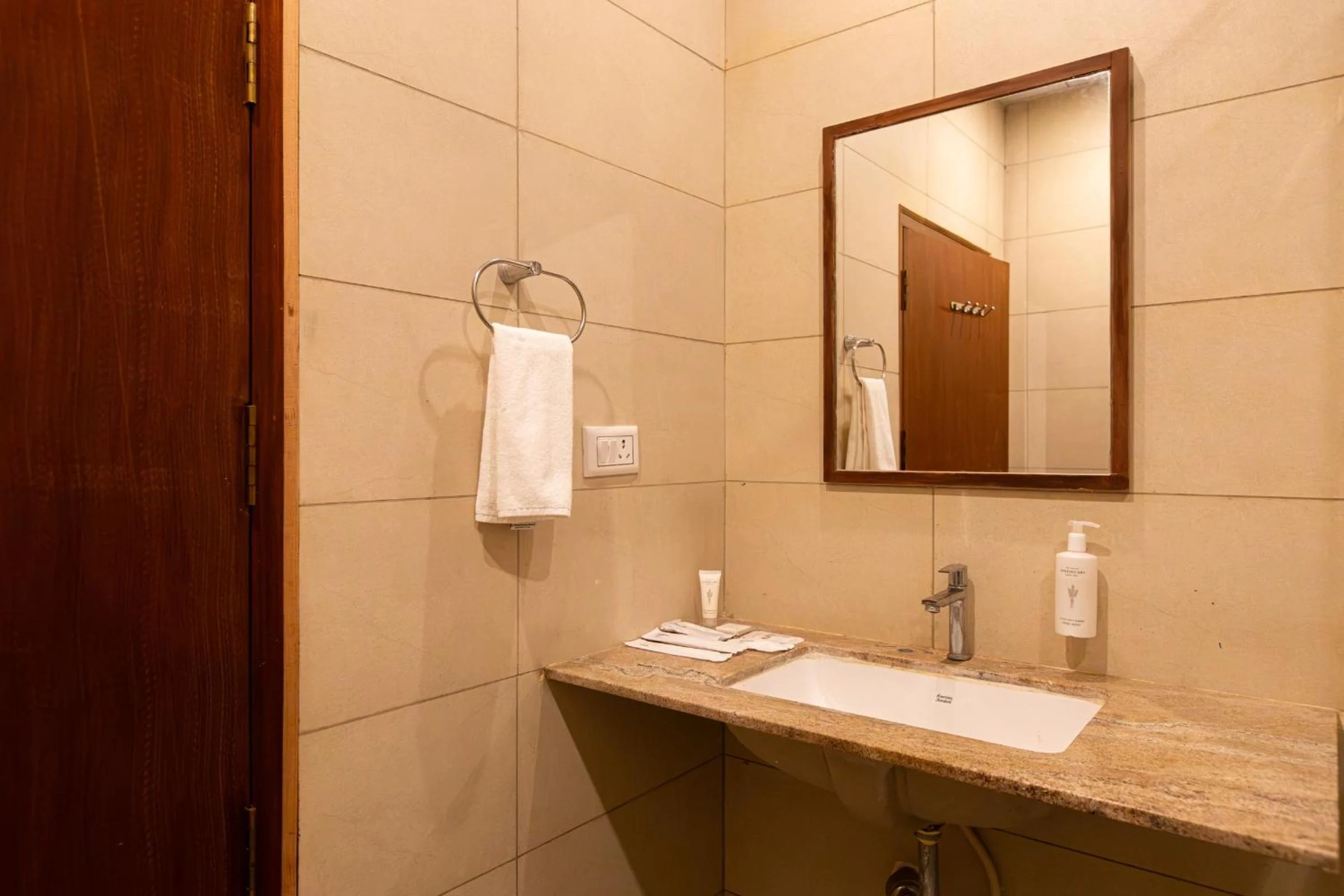A guest bathroom vanity with a wide mirror, countertop basin and folded hand towel