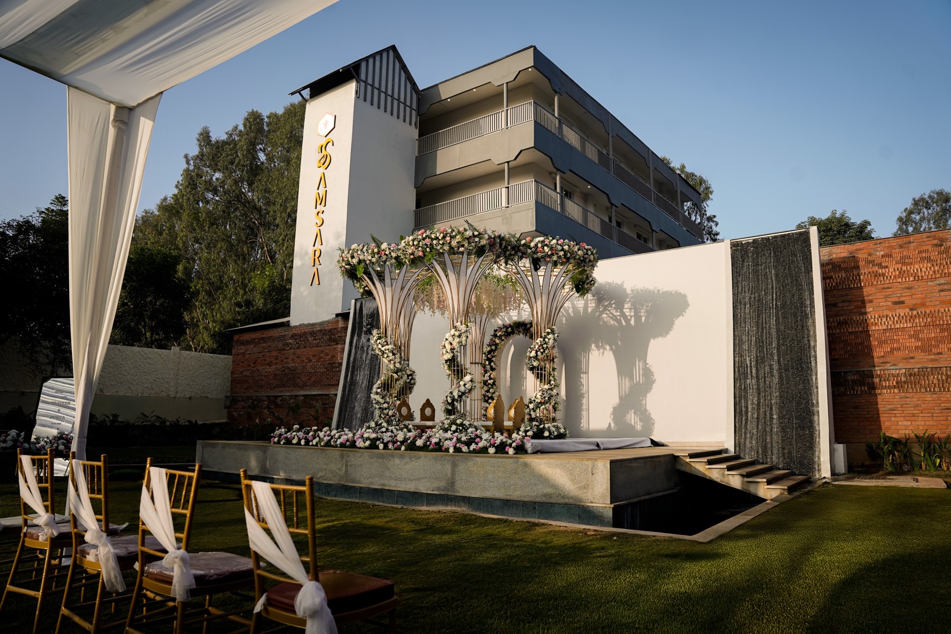 Floral mandap with cascading waterfall and Samsara building