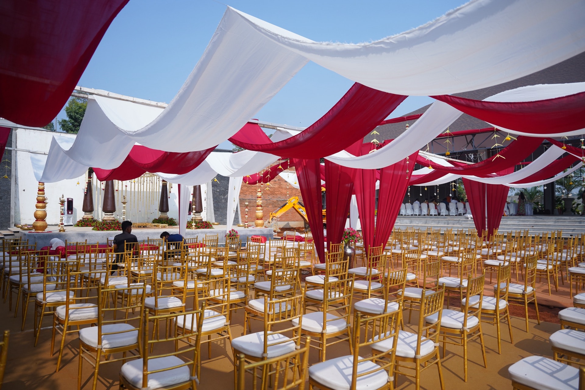 Red and white canopy ceremony setup with golden chiavari chairs
