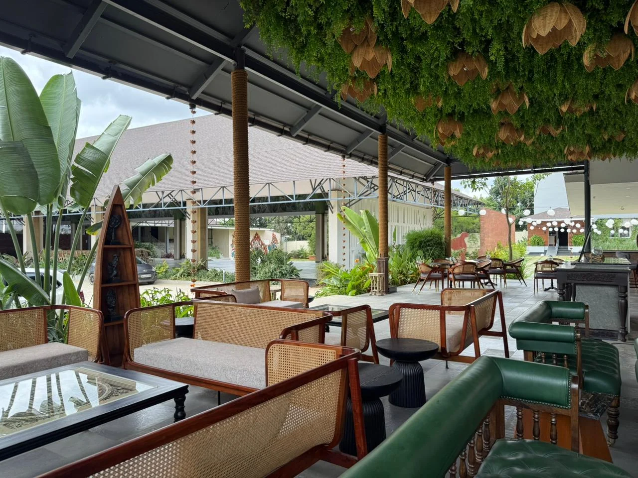 Green sofas and woven chairs in Samsara’s open garden lounge