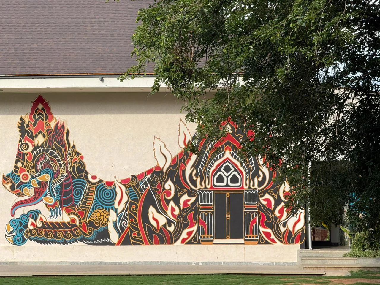 Colourful exterior mural beside Maya Dining Deck, shaded by a tree