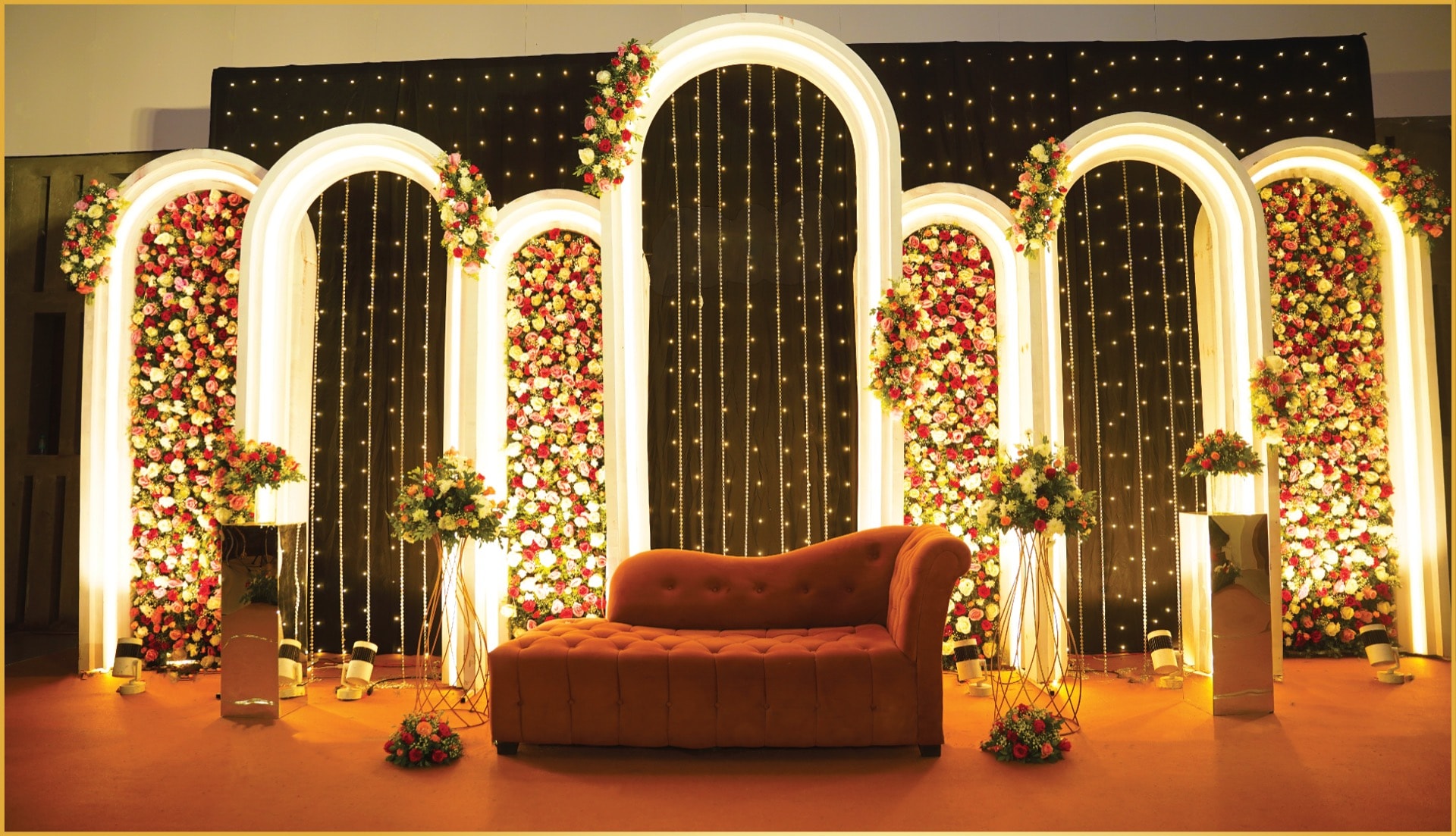 Grand reception stage with arched floral backdrop and LED curtains