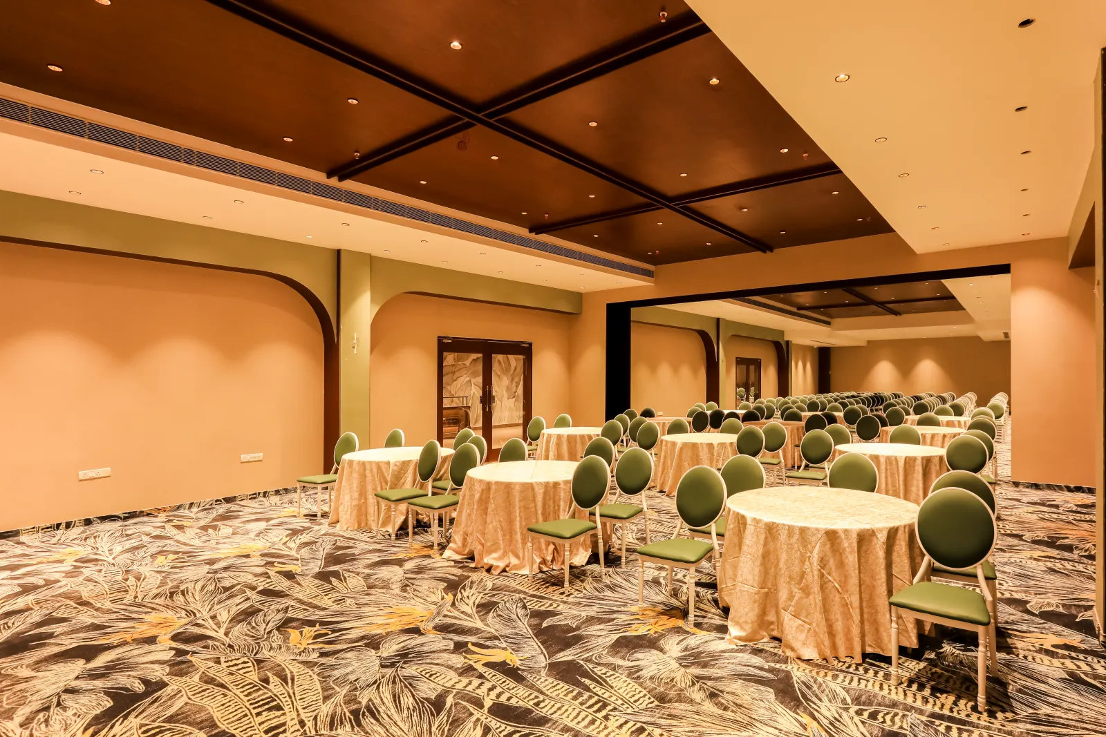 A wider view of Savaya’s banquet layout and timber ceiling