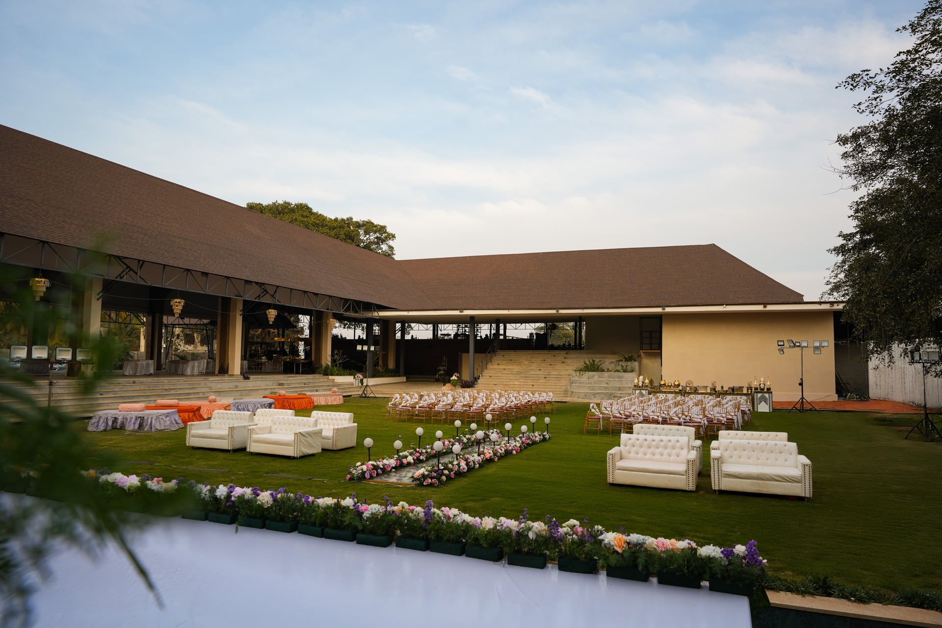 Lounge seating on Padma Lawns beside a flower-lined walkway