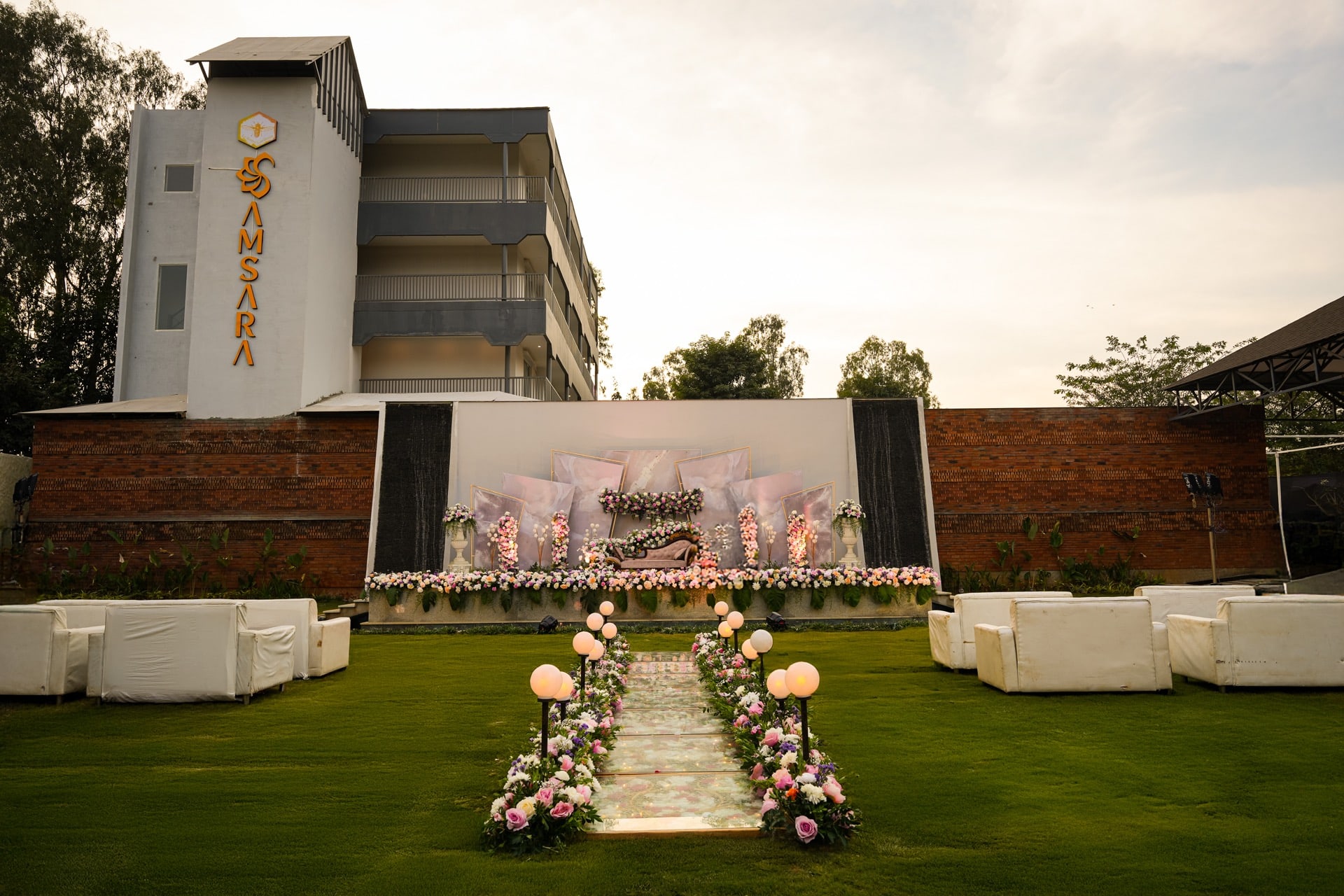 A reception on Padma Lawns at dusk with the stage lit