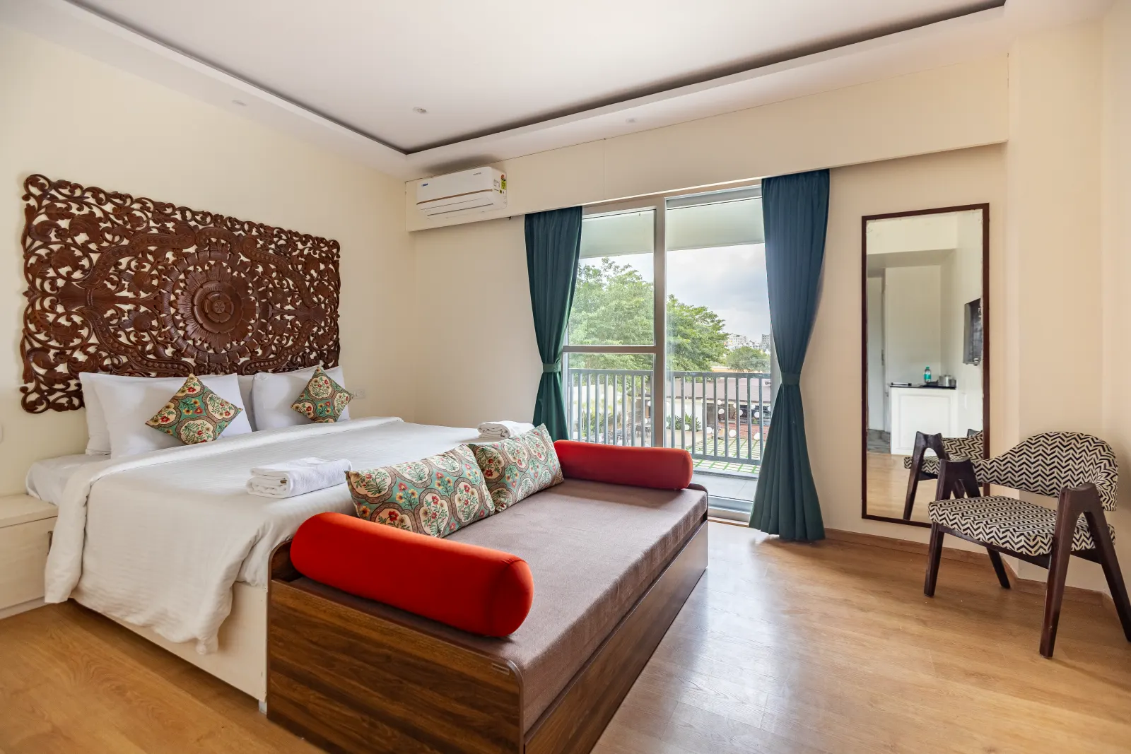 A Rumah Residence with carved headboard, red bolsters and a balcony